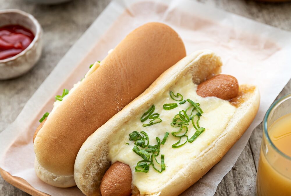 Hotdog met gekonfijte ui, crème van Emmental Entremont en lente-ui